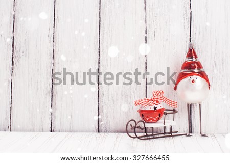 Xmas or new year composition with sledge, little bell and funny bird on white wooden background. Xmas card. Space for text. Selective focus