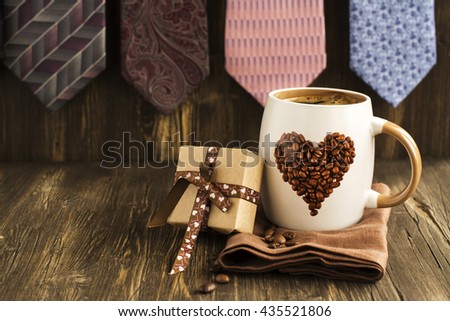 Happy Fathers Day Card. Mug of coffee, gift box and ties background. Vintage style. Toned image. Selective focus