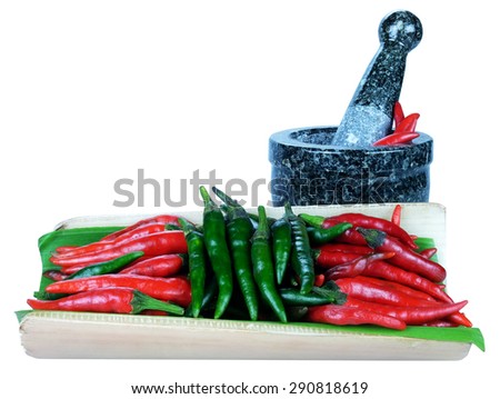 red and green chillies mortar and pestle on white background