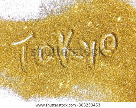 Blurry inscription Tokyo on golden glitter sparkles on white background