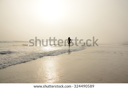 Woman walking on the beach.