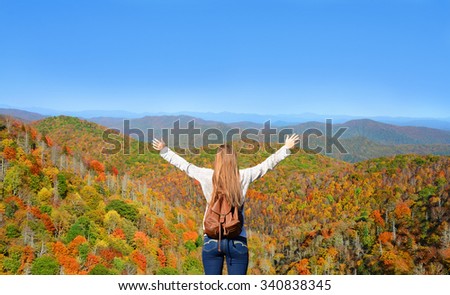 Girl enjoying time on top of the mountain on her fall hiking  trip.