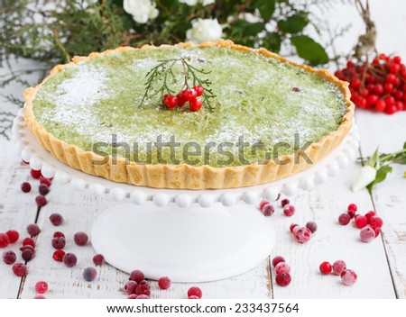 Tart with white chocolate and tea match is decorated with cranberries