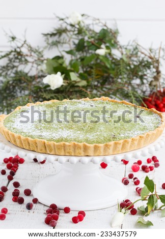 Tart with white chocolate and tea match is decorated with cranberries