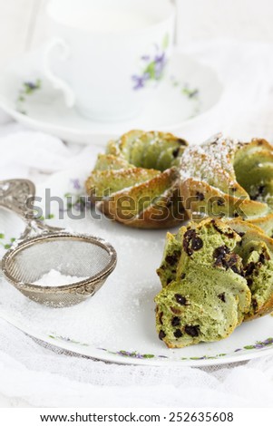Muffins with tea match and chocolate ,sprinkled with powdered sugar