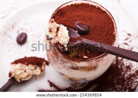 Tiramisu, traditional Italian dessert in a glass,with chocolate spoons.selective focus