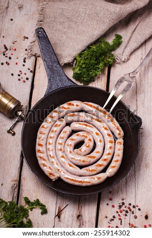 Sausages fried homemade frying in a cast iron skillet,composition spiral.selective focus