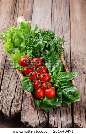 Vegetables and herbs for salad, vintage shoulder blade.Cherry tomatoes,Basil, arugula and lettuce.selective focus