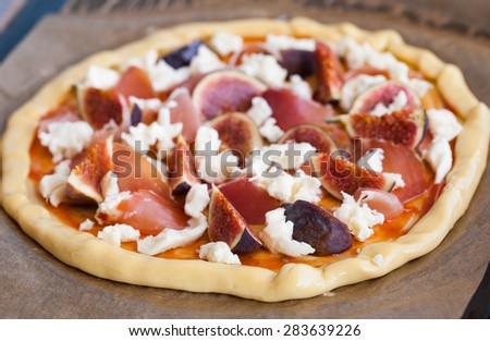 The pizza dough with the ingredients, prosciutto,figs and cheese.selective focus