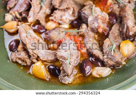 Lamb meat cooked in a tagine with olives, garlic, lemon and rosemary.