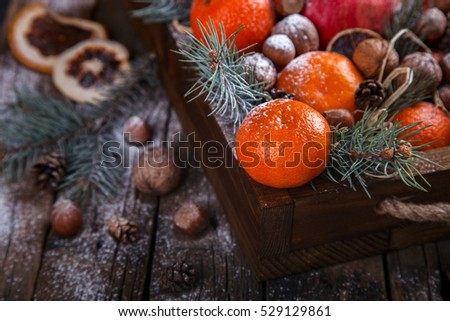 Christmas New Year  card. Tangerines,Nuts,Pomegranate,Citrus,Tree Branches  in a wooden box.Festive Background.Vintage style.selective focus.