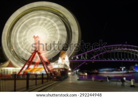 Ferris wheel in theme park and Sydney Harbour Bridge, Vivid Sydney festival of light, music and ideas.