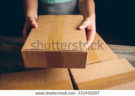 Girl\'s hands holding the package on the table