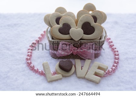 Pretty Rolled Chocolate Heart inside Vanilla Heart Sugar Cookies in a Ceramic bowl wraps with Burlap with the word \