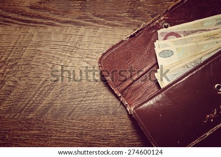 Old purse with soviet banknotes retro toned on wood background