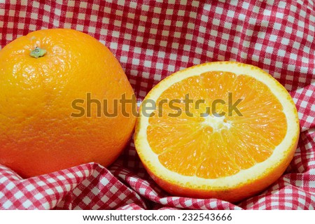 Orange is placed on the fabric in the picnic basket