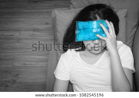 Top view of Asian woman with cold pack on her forehead for relief fever headaches and migraines, black and white tone