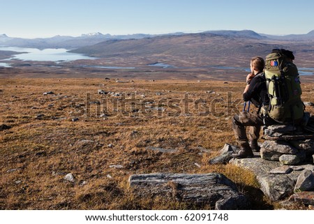 sitting Hiker with heavy backpack in Lapland