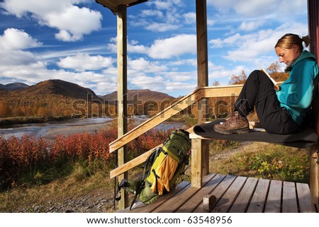 female hiker take a break on the front of a hut