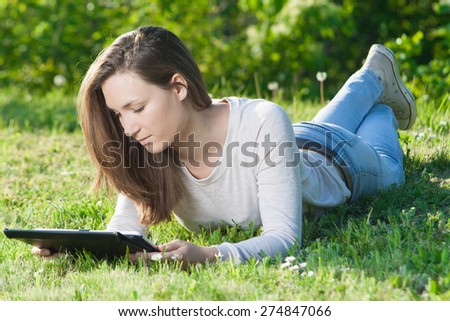 Young woman using computer tablet pc outdoor in the park