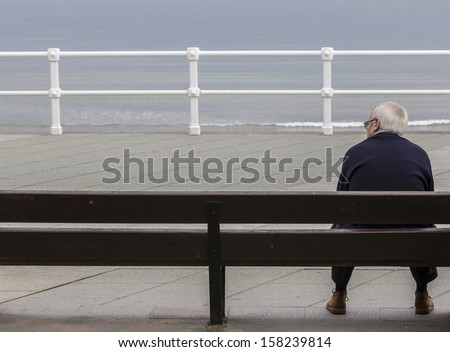 Old man sitting in front of the sea