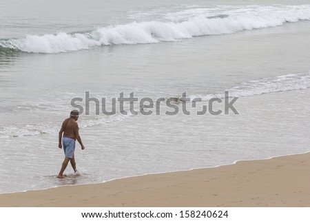 Old man walking along the beach