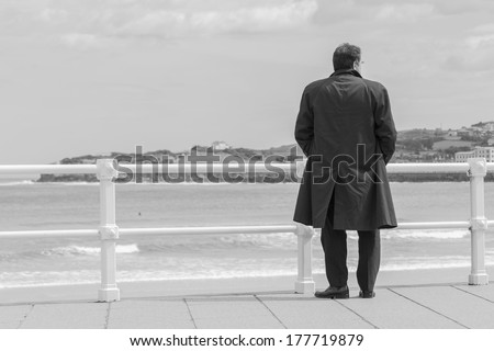 man with trench coat waterfront