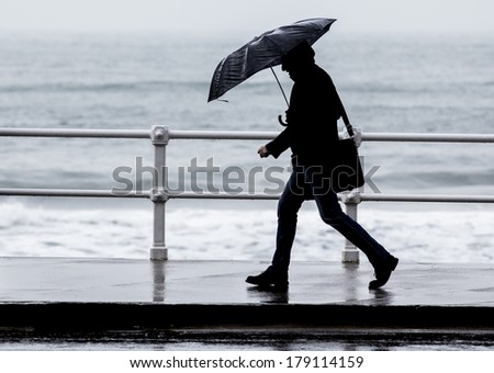 Man with umbrella walking in the city