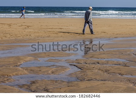 Old man walking on the beach