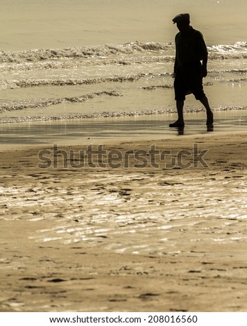 Old man walking along the seashore