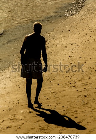 Old man walking on the beach sand