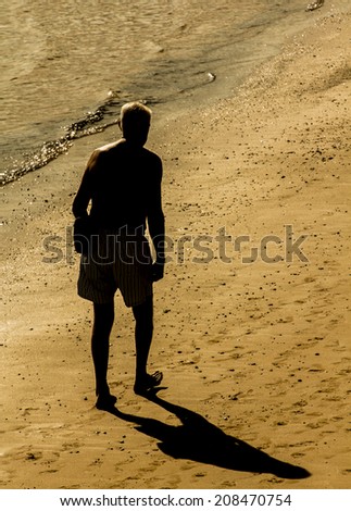Old man walking on the beach sand