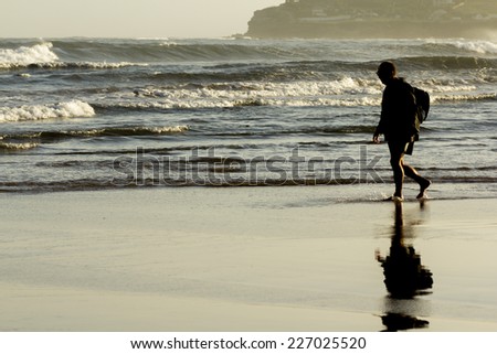 Old man walking by the sea shore