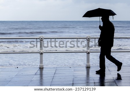 man with umbrella walking around town