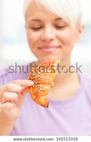 Photo of hungry looking woman starring at a croissant