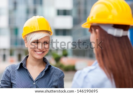 Photo of smiling female constructors who meet each other