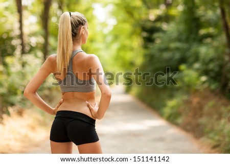 photo of sexy female with tonic bottom looking at running path