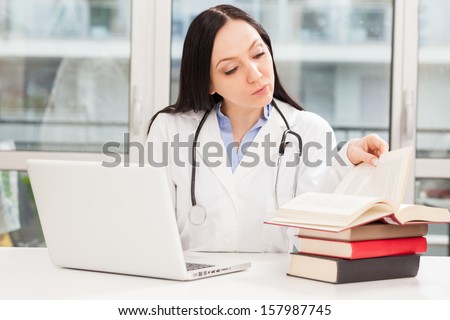 Photo of female doctor studying with her books