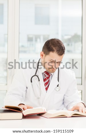 Male doctor is studying with books