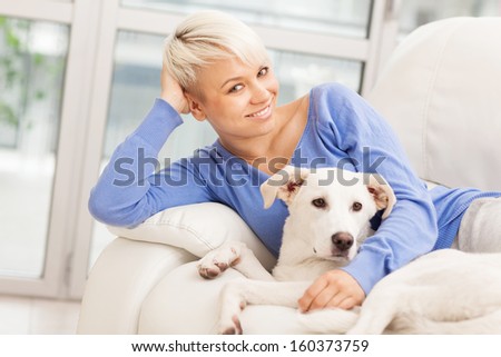 photo of woman sitting with young dog on the sofa