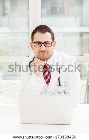 Photo of young male doctor with notebook in his studio