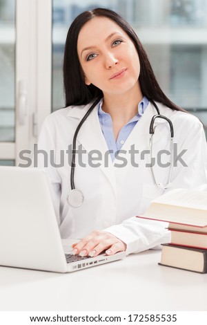 Photo of female doctor studying with her books