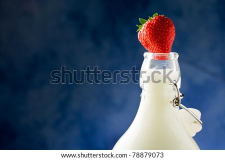 photo of milk bottle with fresh red strawberry on it