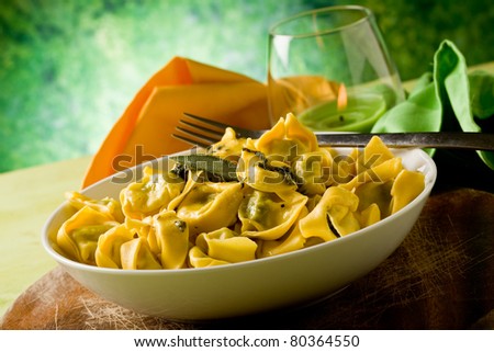 delicious italian fresh tortellini with butter and sage with green background