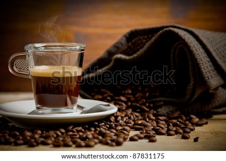 photo of hot smoking coffee inside glass cup on wooden table