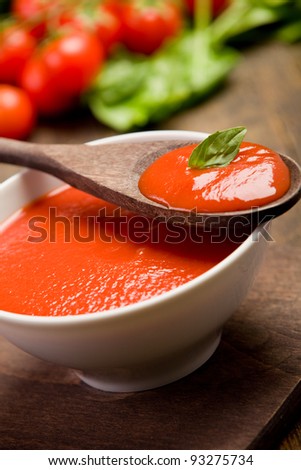 fresh red tomato sauce with basil leaf and wooden spoon