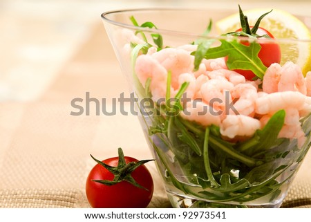 shrimps cocktail appetizer on brown towel with lemon and cherry tomatoes