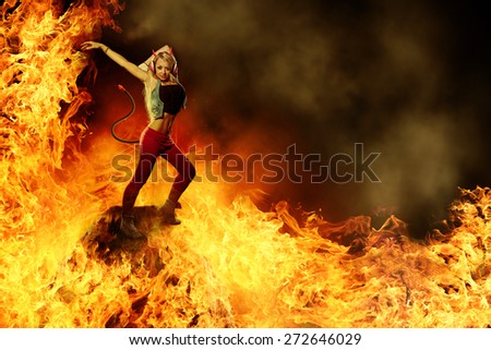 Blonde female devil is dancing in the fire