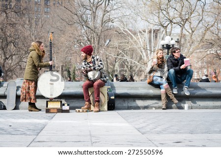 NEW YORK CITY - MARCH 8th 2015: young artist plays music performance in Washington Square Park, Manhattan, USA