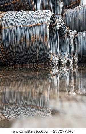 A pile of wire imported rod coil stock placing in water after a heavy rain for industrial background